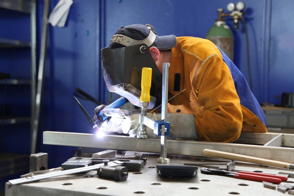 Man welding a metal in a work environment