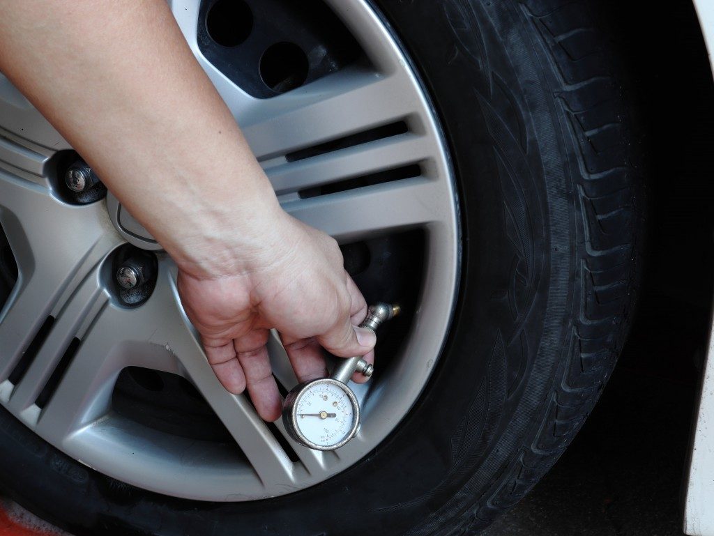 person checking the tire pressure