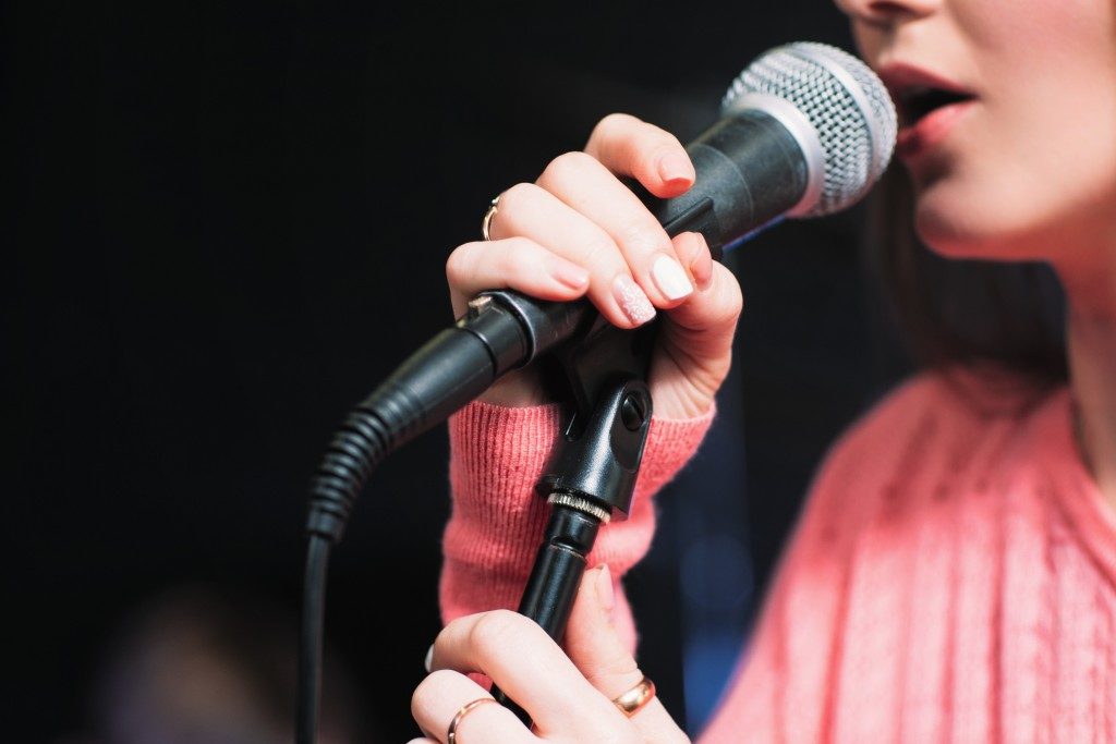 Microphone and unrecognizable female singer close up