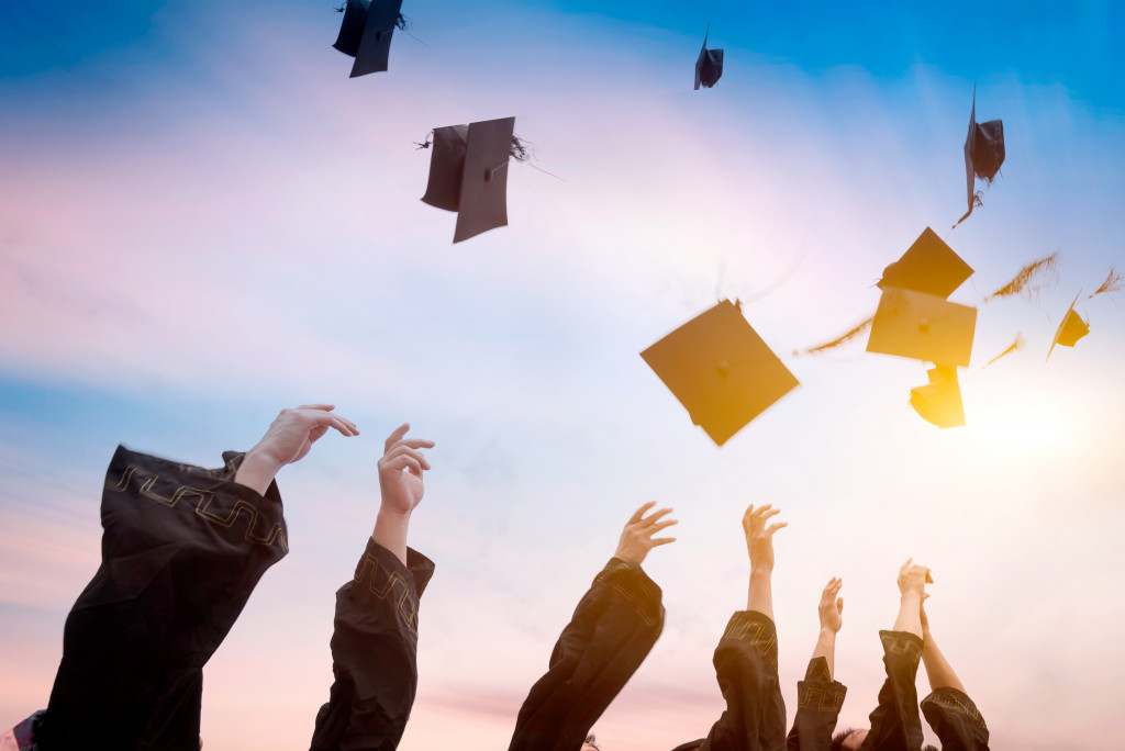 graduates throwing graduation hats in air
